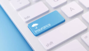 Tastatur med knap med navnet "Insurance" og en paraply ovenover.